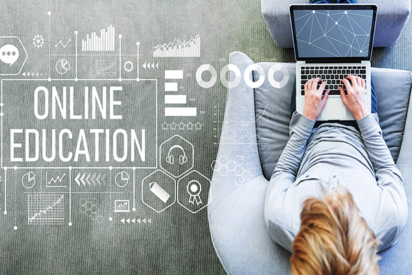Woman in chair working on a laptop. Online Education in white text with various shapes and icons.